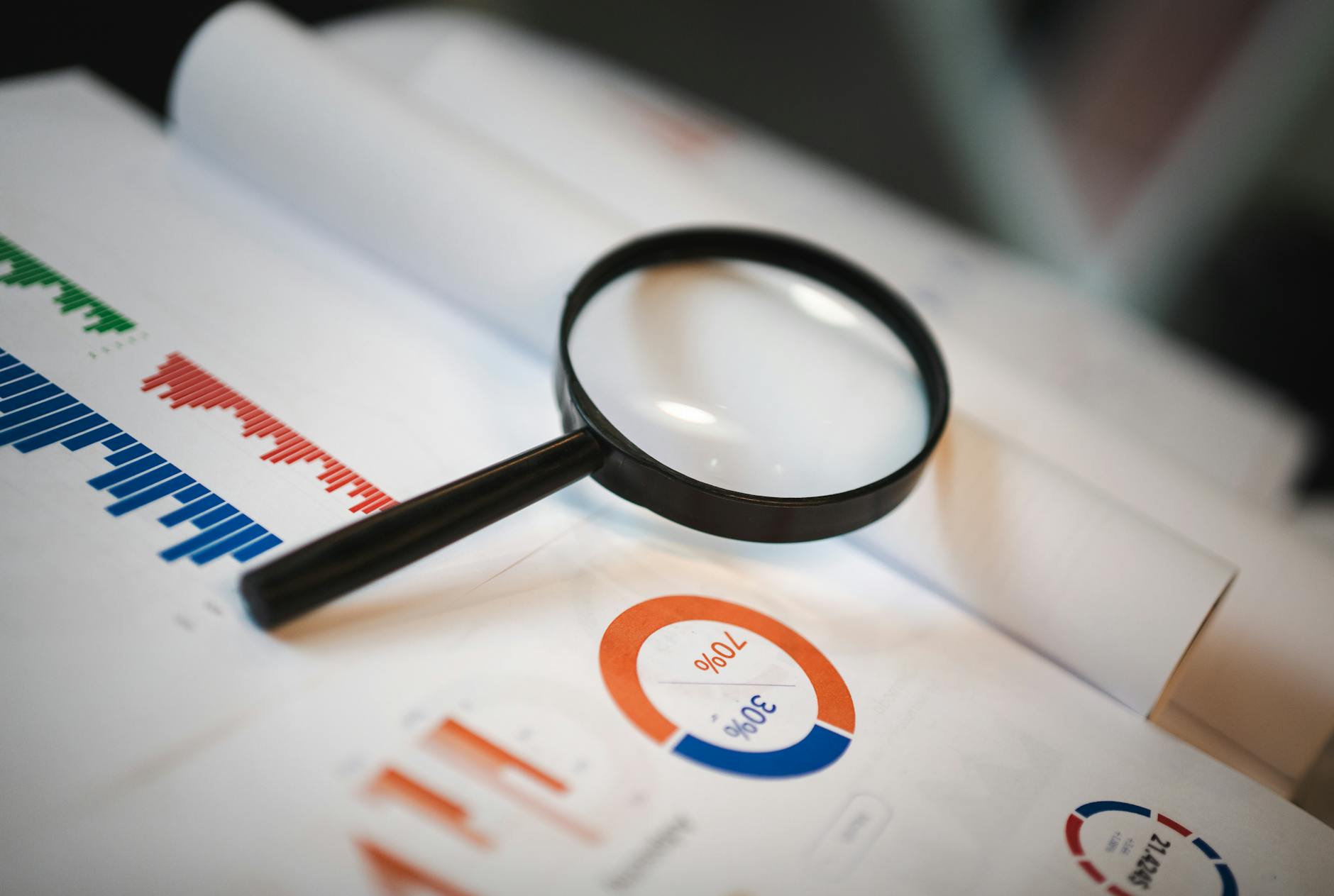 Magnifying glass on financial charts and graphs