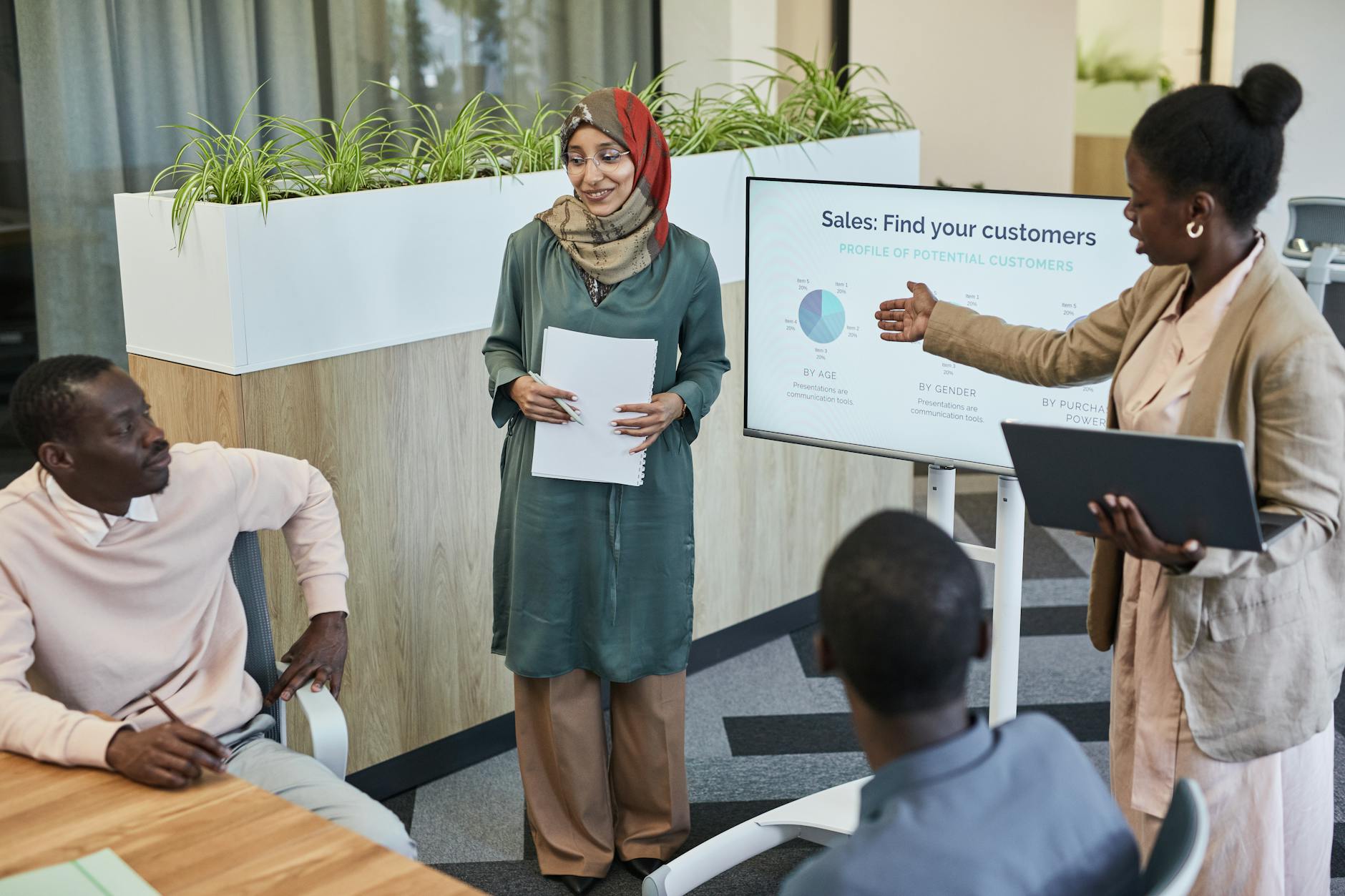 Team reviewing sales forecast data on a screen during a business meeting